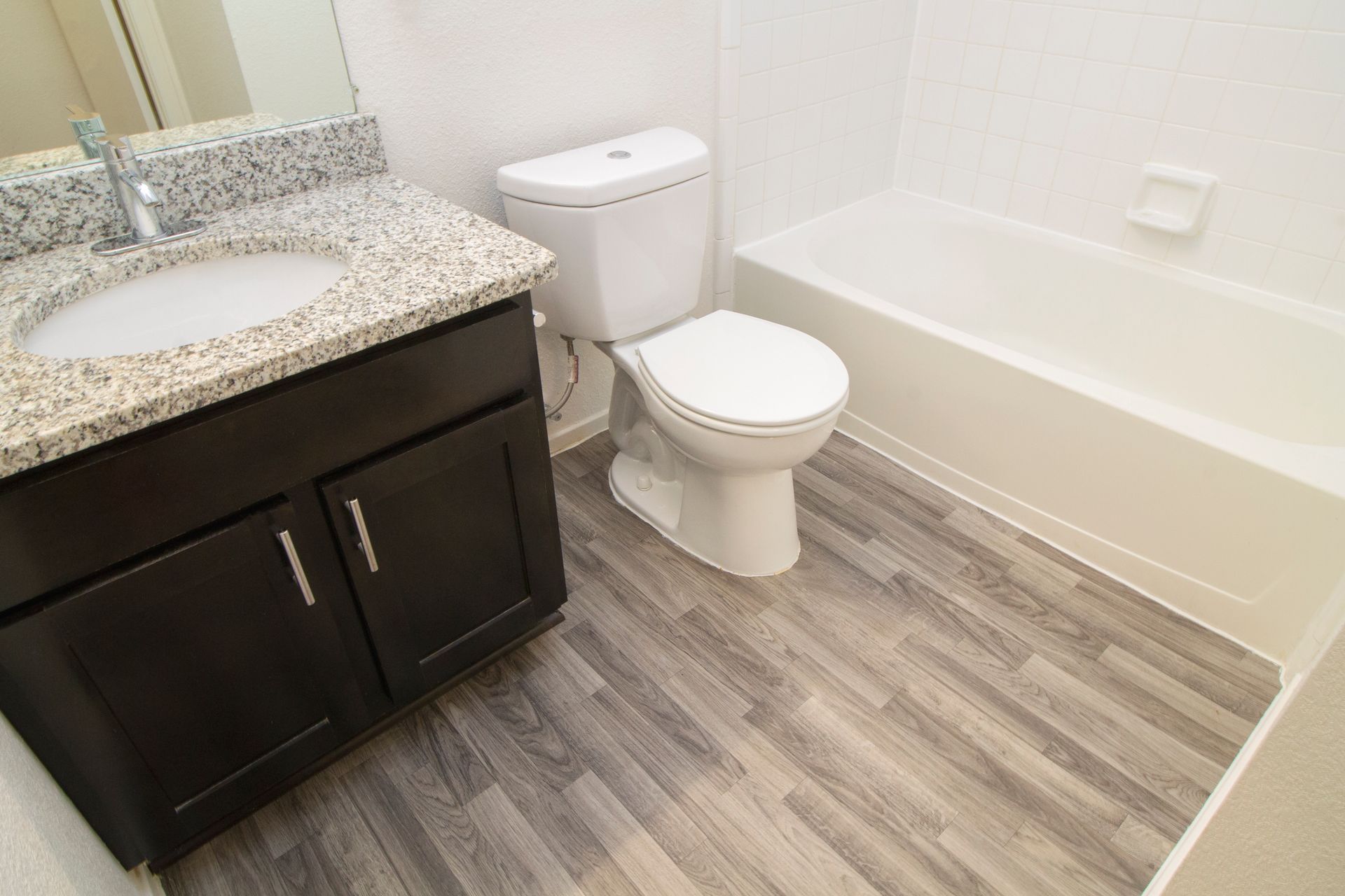 A bathroom with a toilet , sink and bathtub.