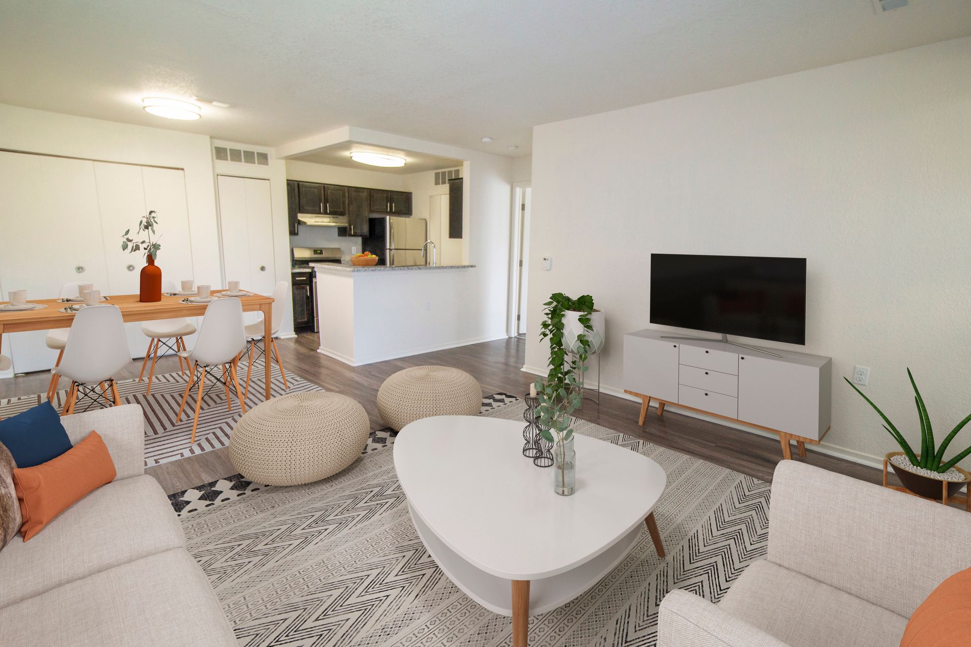 A living room with a couch , chair , coffee table and television.