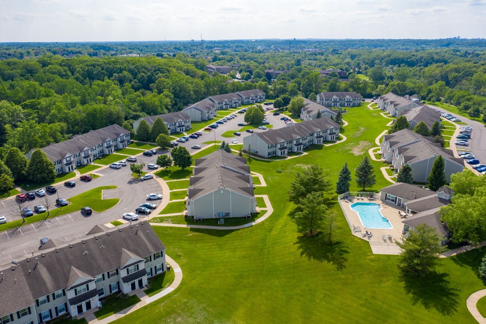An aerial view of a residential area with lots of buildings and a pool.