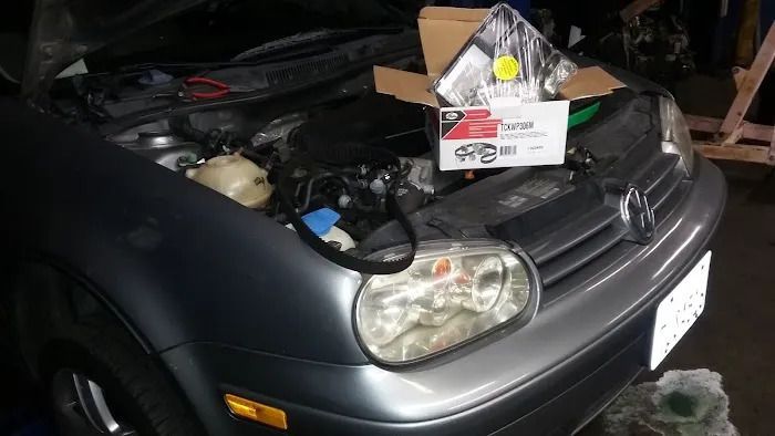 A car with the hood up and a box on the hood.