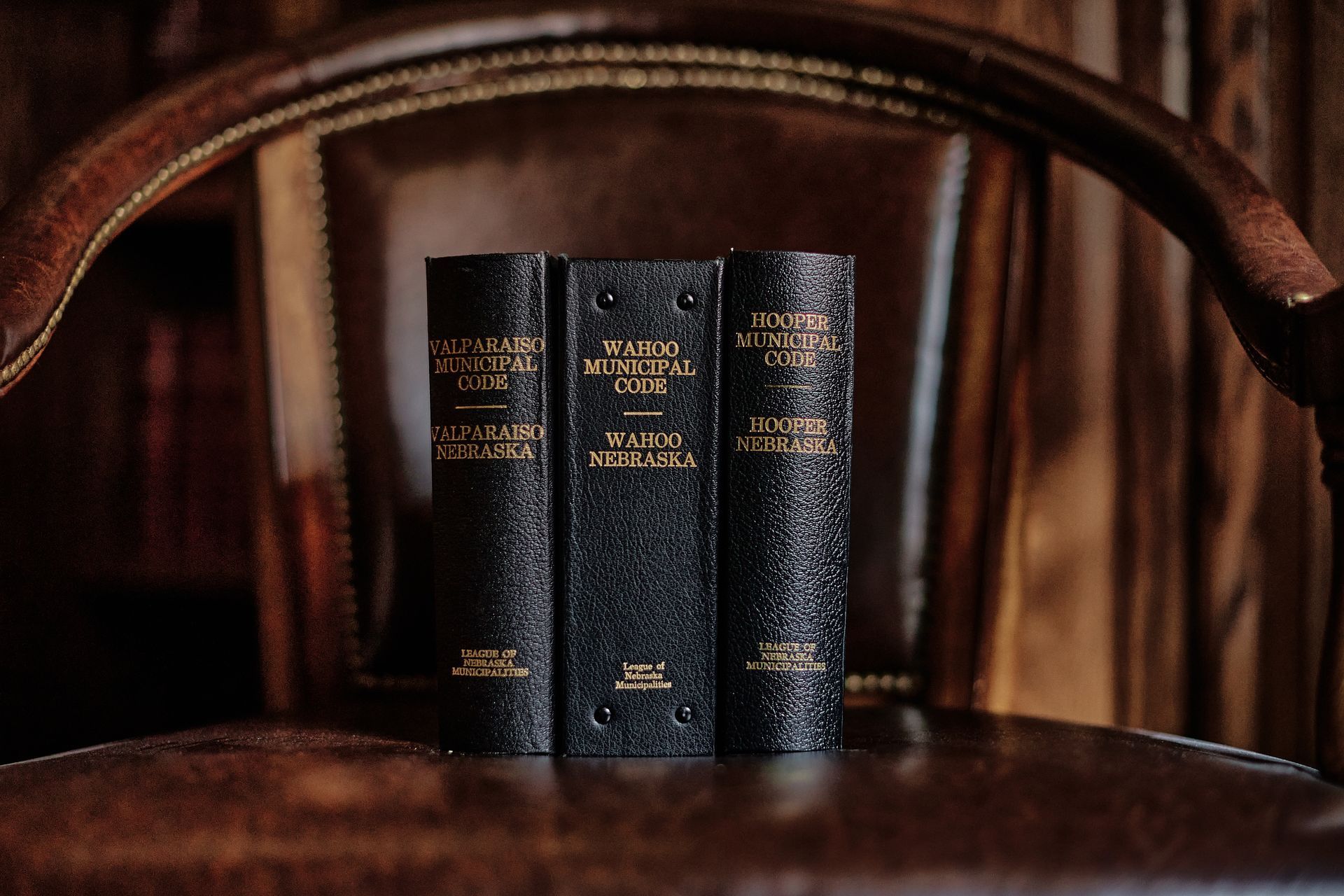 Three books are stacked on top of each other on a window sill.