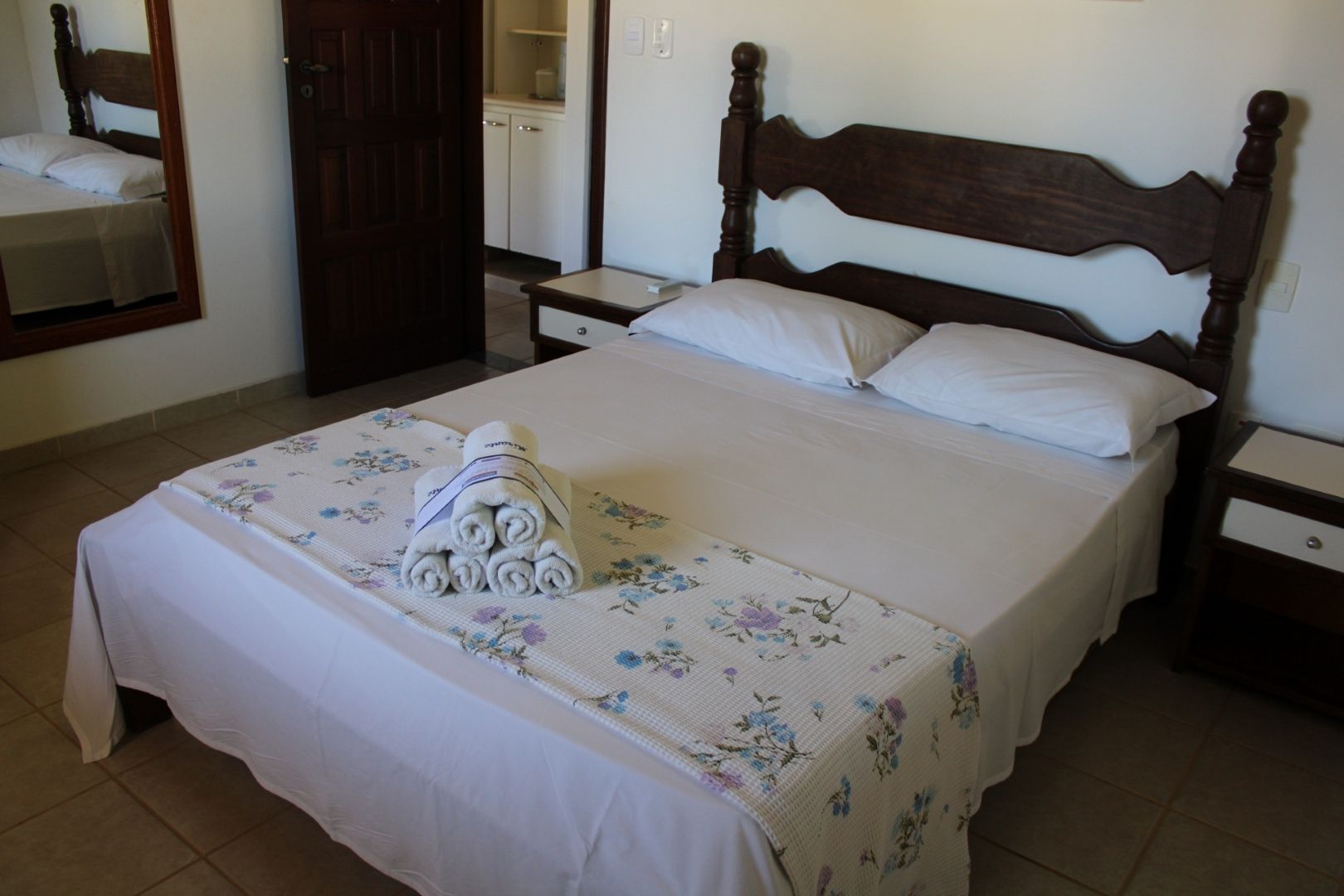 Um quarto com uma cama grande e um espelho