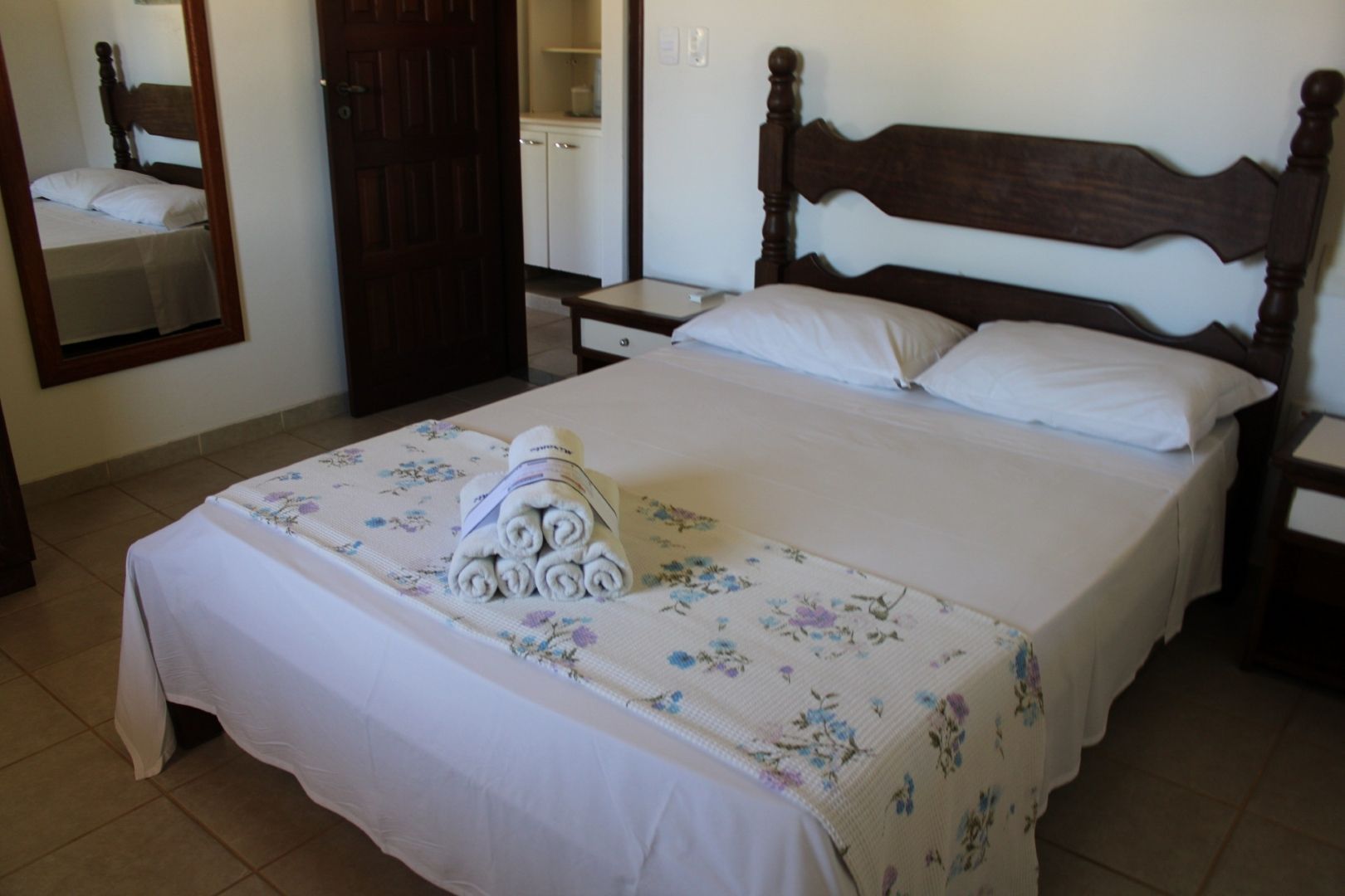 Um quarto com uma cama grande e um espelho