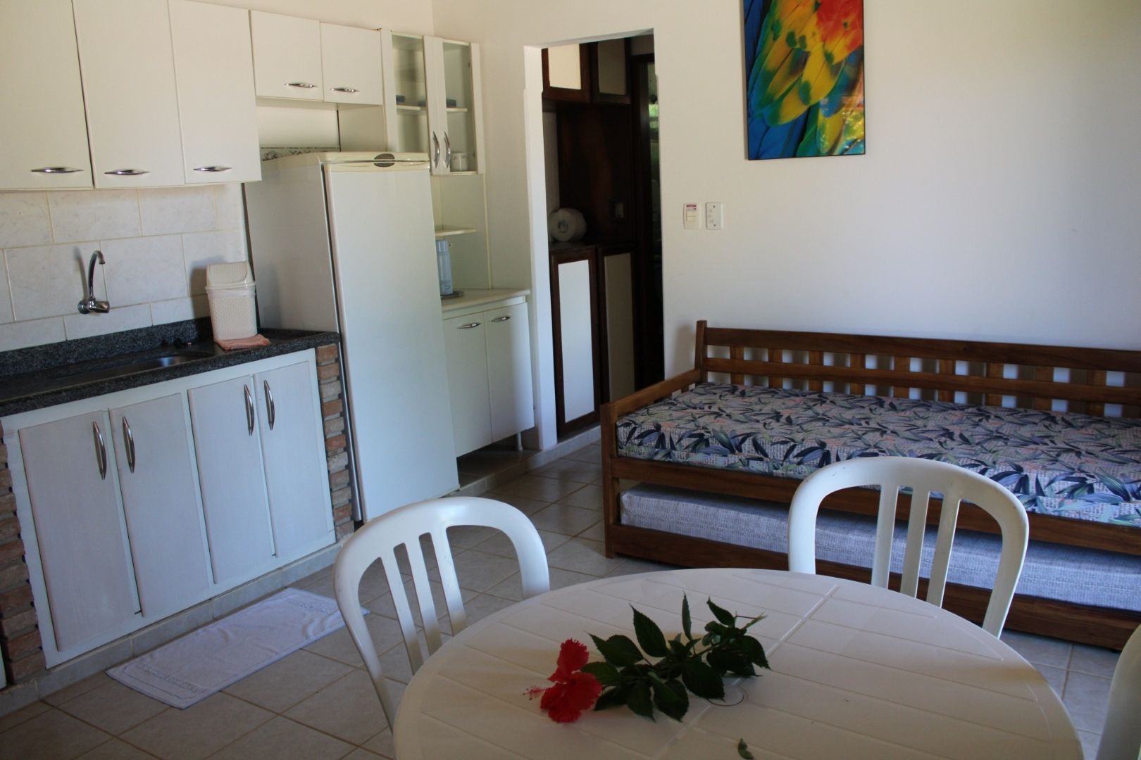 Uma sala de estar com uma mesa e cadeiras e uma cama