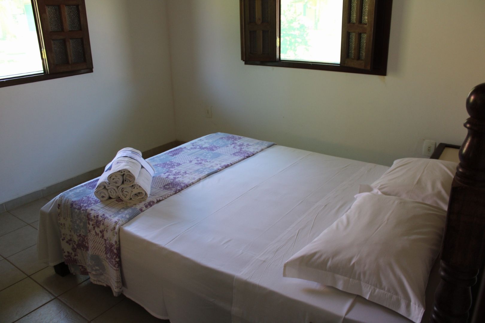 Um quarto com uma cama e uma janela com venezianas