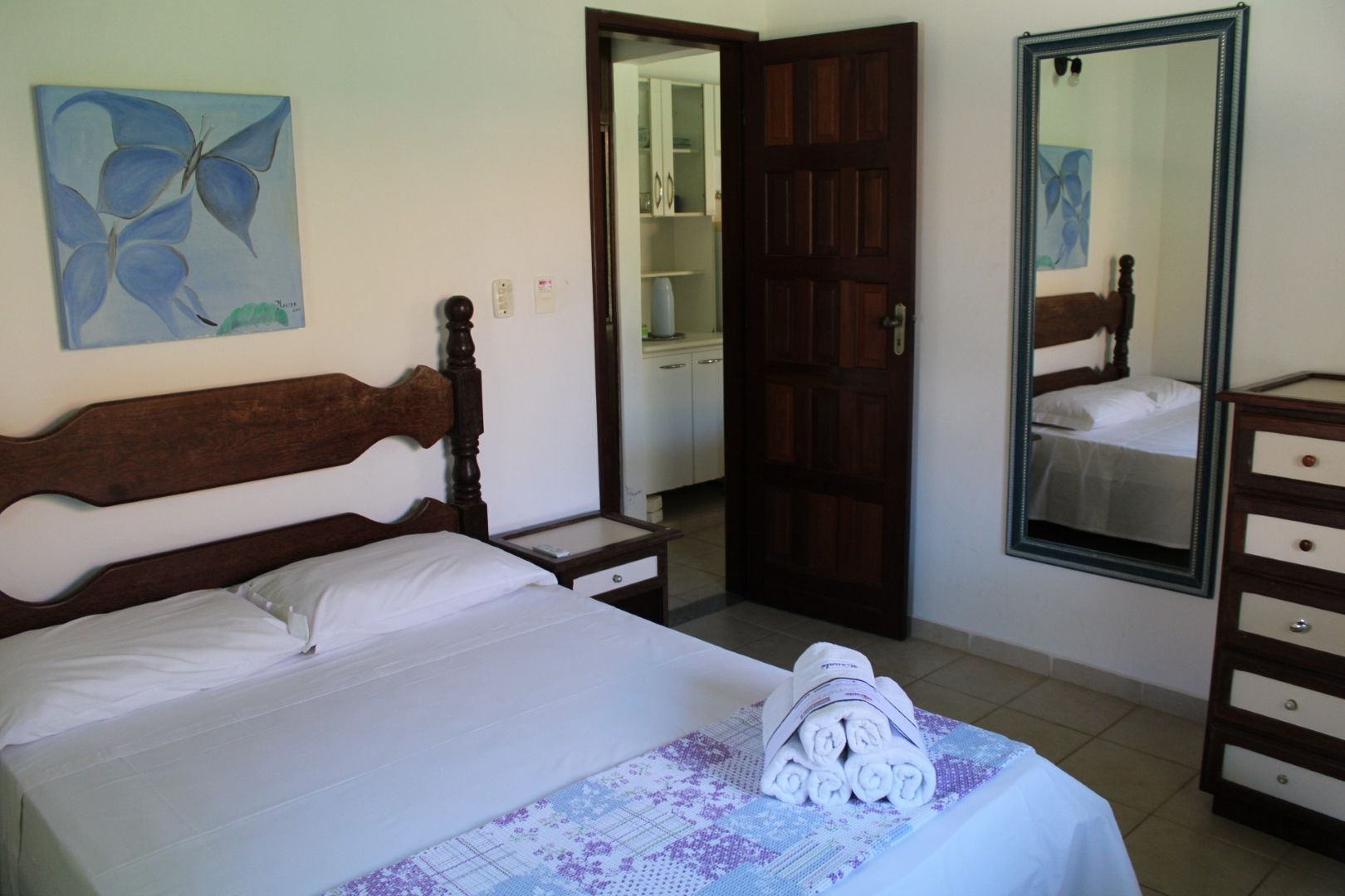 Um quarto com uma cama grande e um espelho