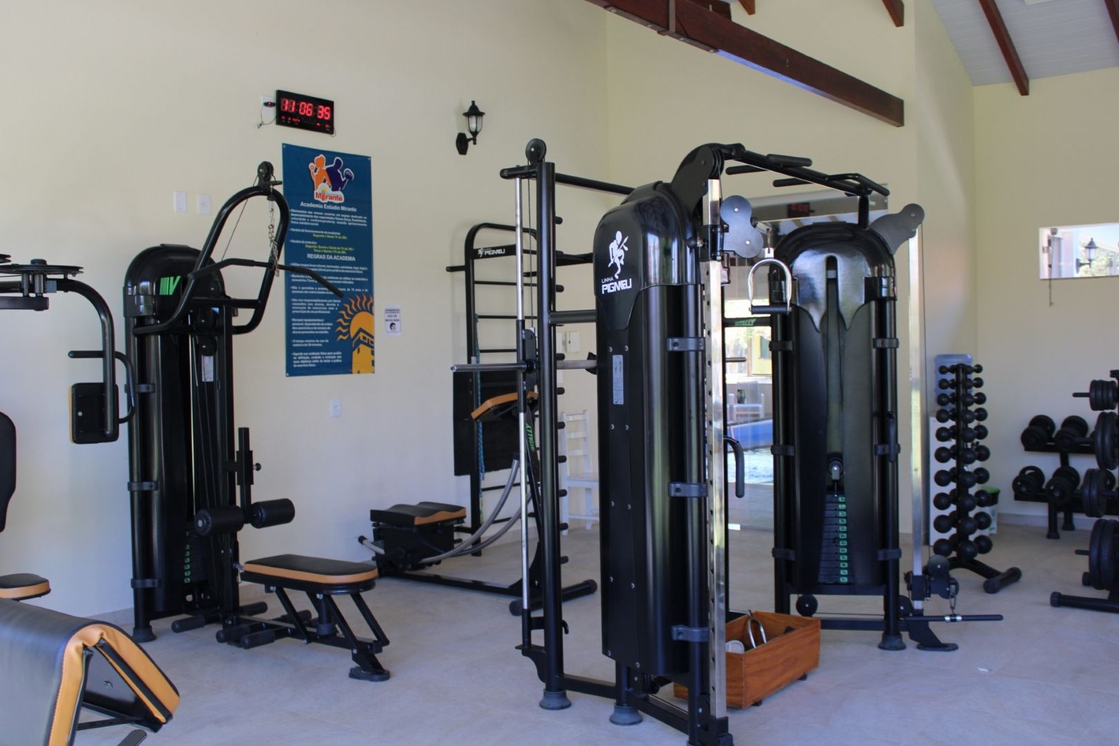 Uma academia cheia de equipamentos de ginástica e uma placa na parede.