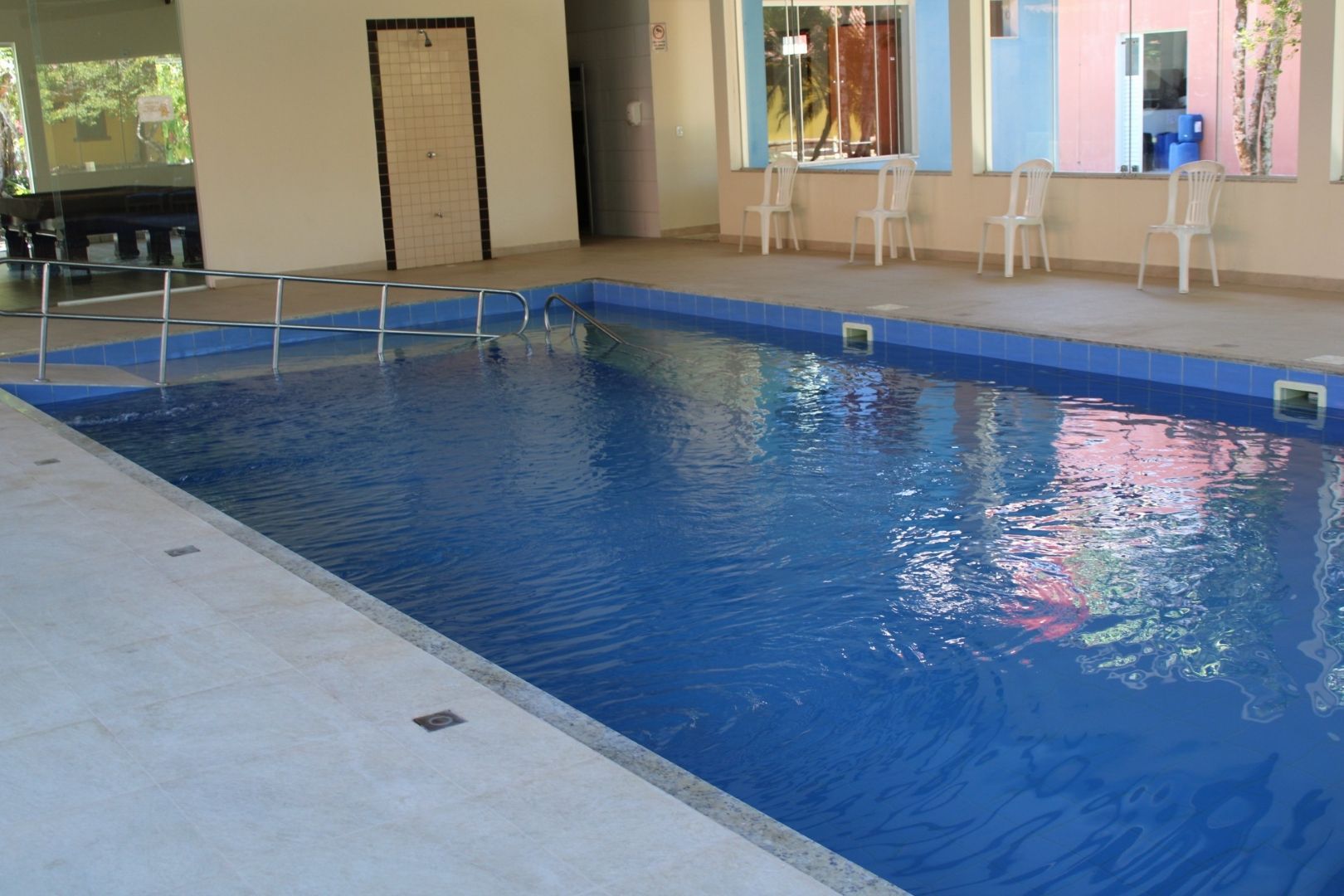 Uma grande piscina coberta com cadeiras ao redor