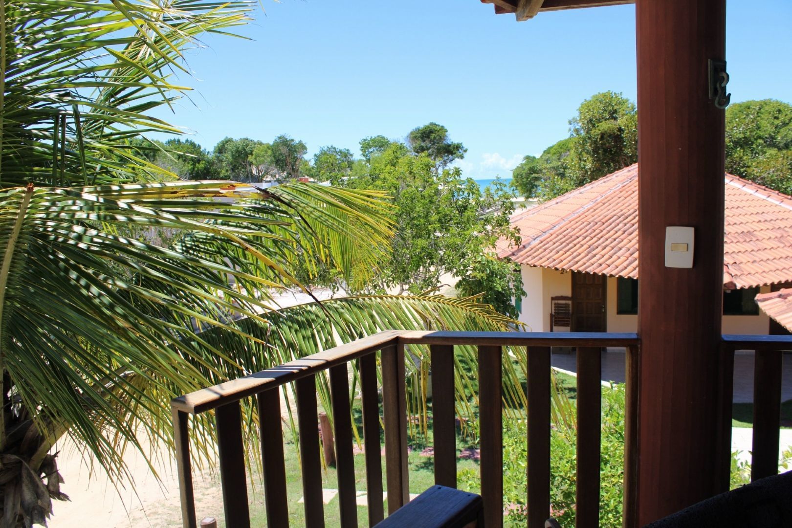 Uma varanda com vista para uma casa e árvores