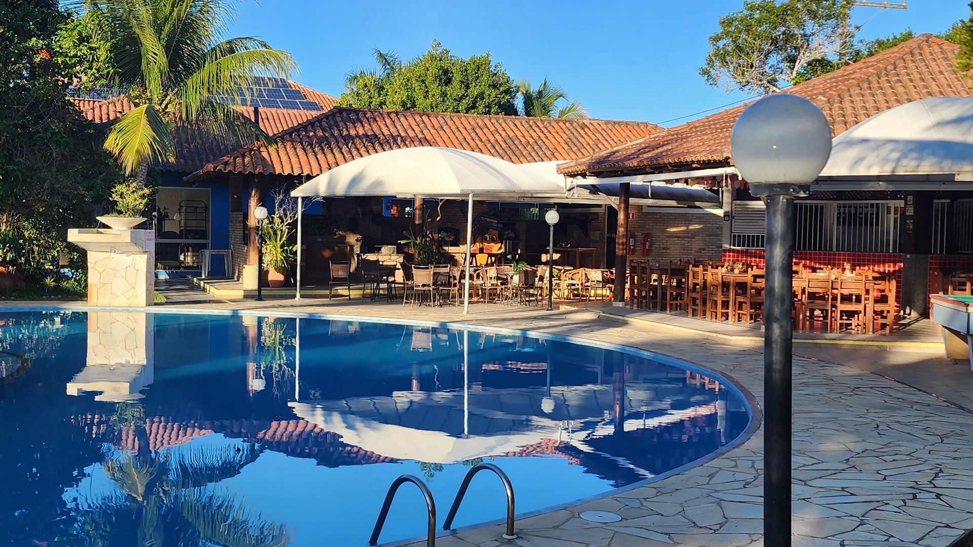 Uma grande piscina com um restaurante ao fundo