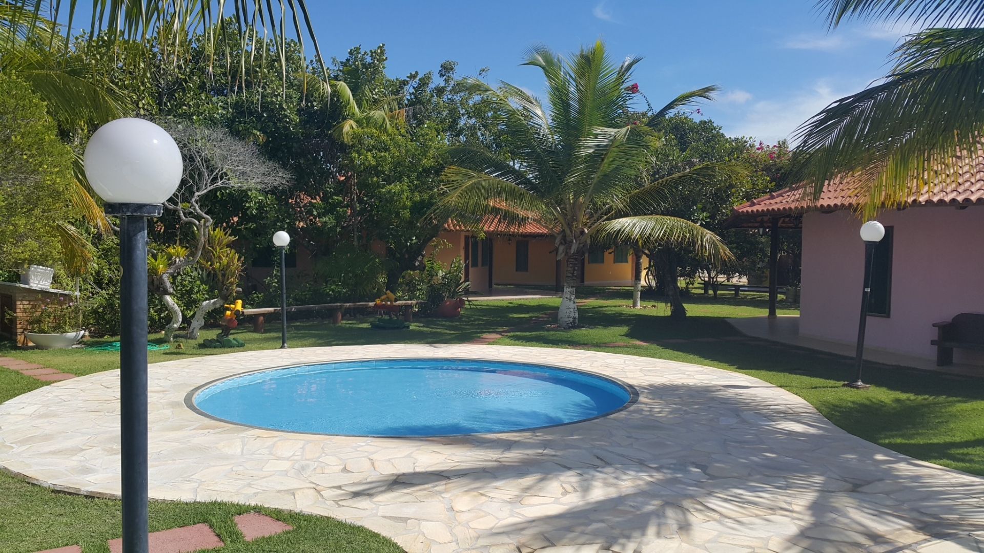 Há uma piscina no meio de um campo verdejante.
