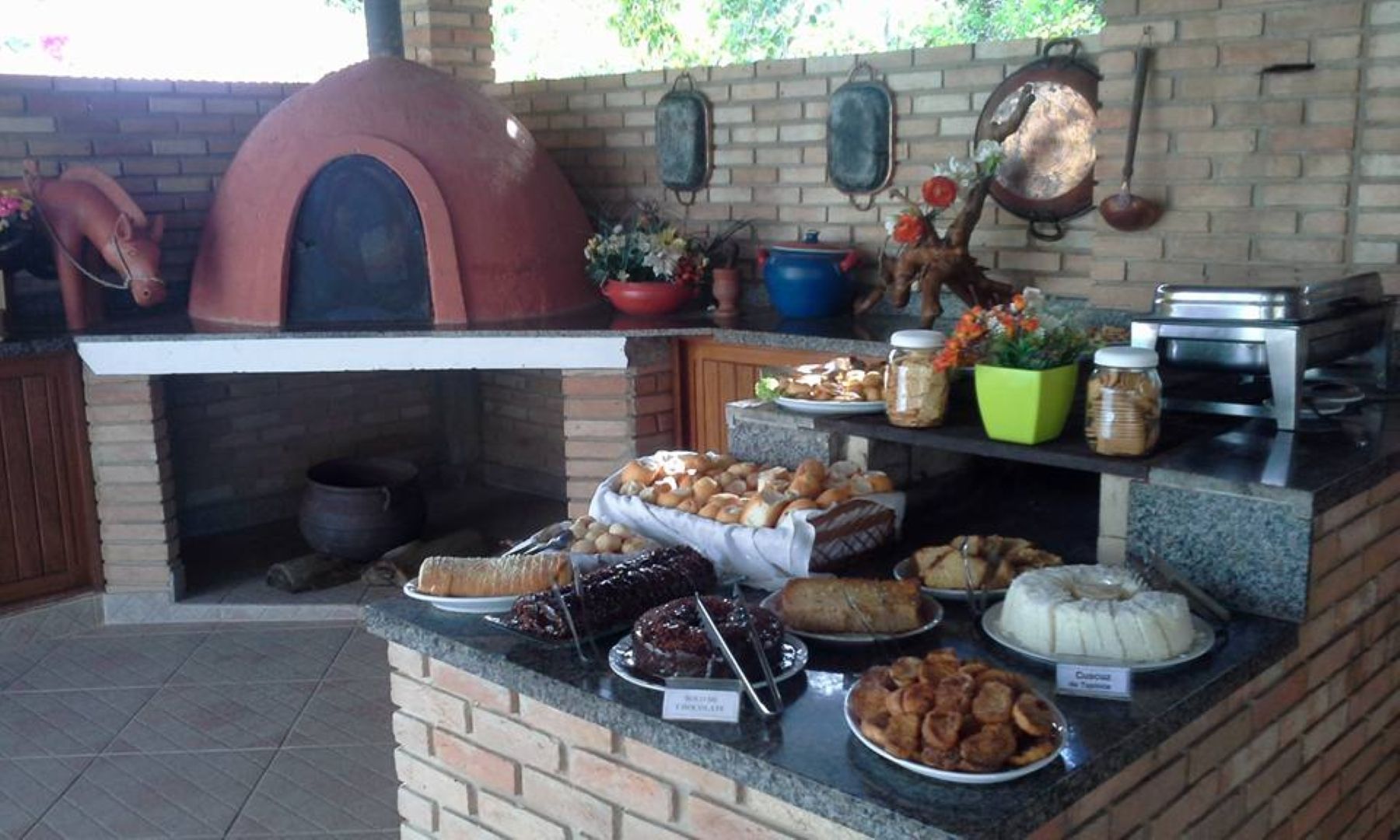 Um forno de tijolos está atrás de um balcão cheio de comida