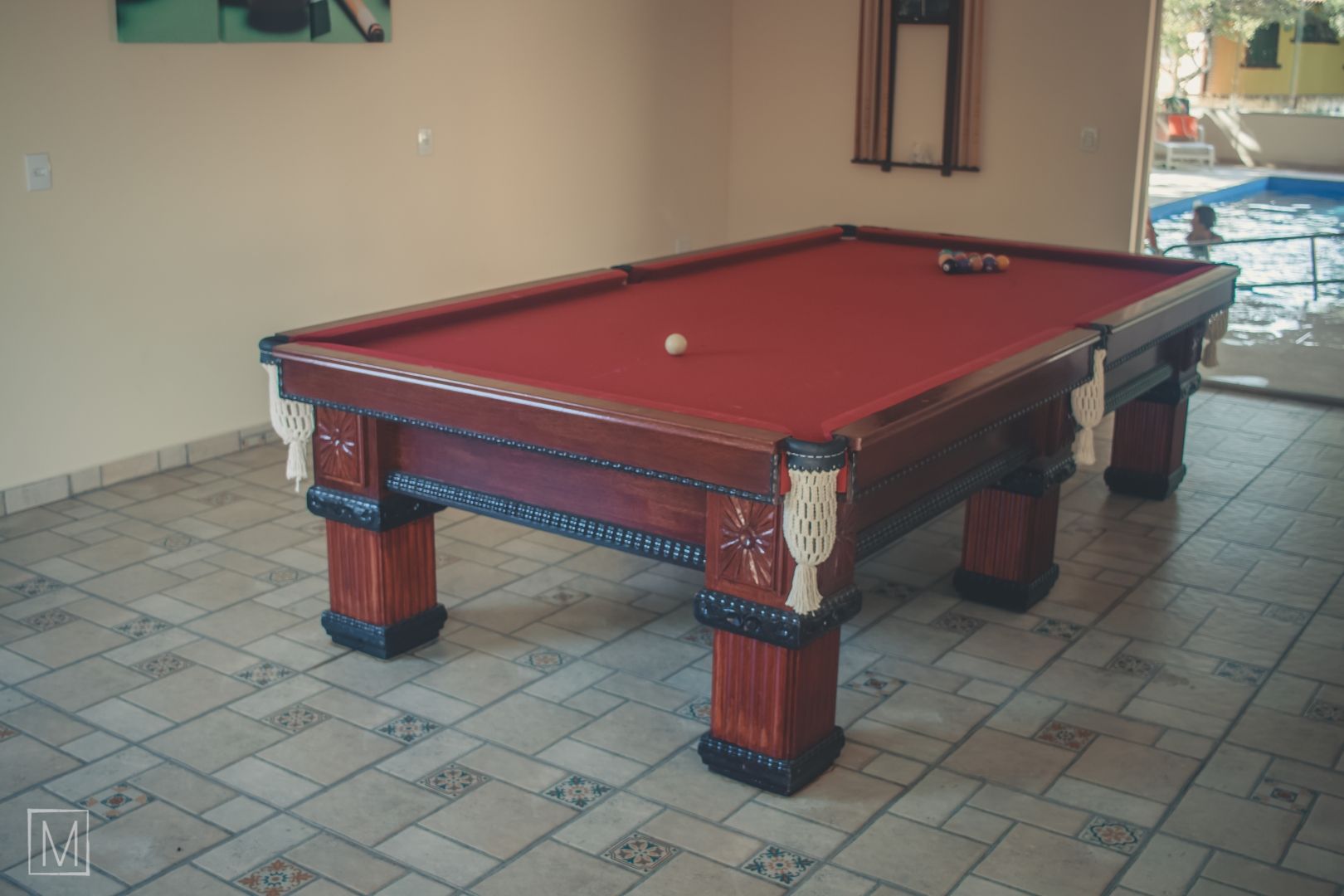 Uma mesa de sinuca em uma sala com uma bola de bilhar nela.