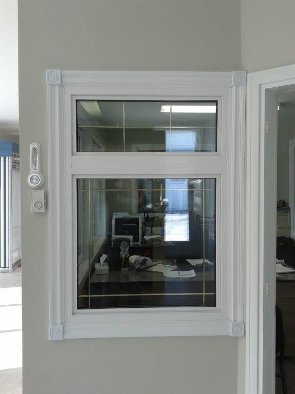 Une fenêtre dans une pièce avec un ordinateur sur le bureau.