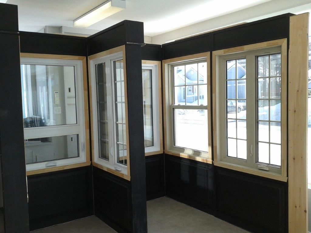 Une pièce avec beaucoup de fenêtres et des murs noirs