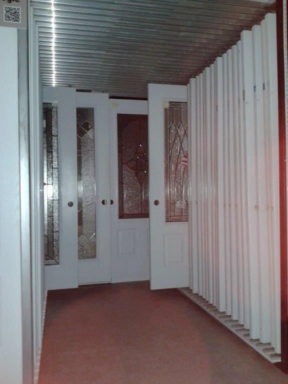 Un couloir avec des portes blanches et des vitraux