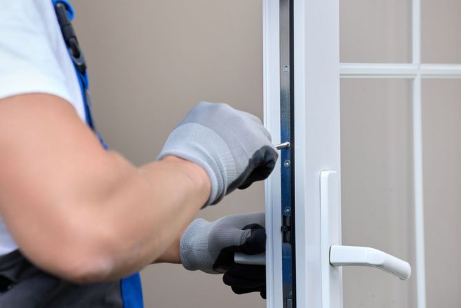 Un homme répare une porte avec un tournevis.