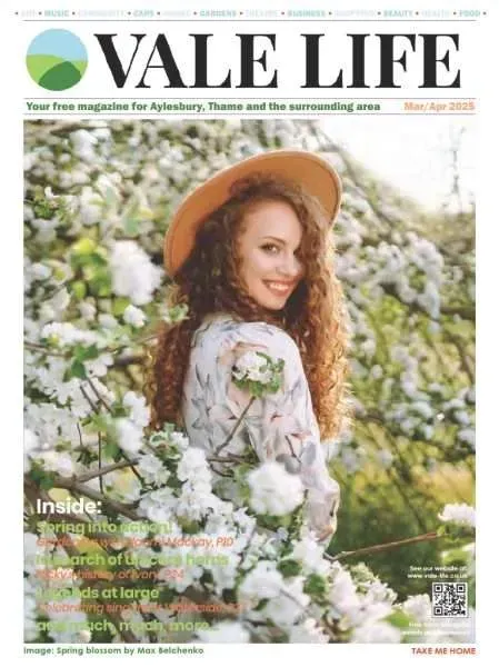 Magazine cover: Woman in hat smiles amidst blooming white flowers, Vale Life magazine.