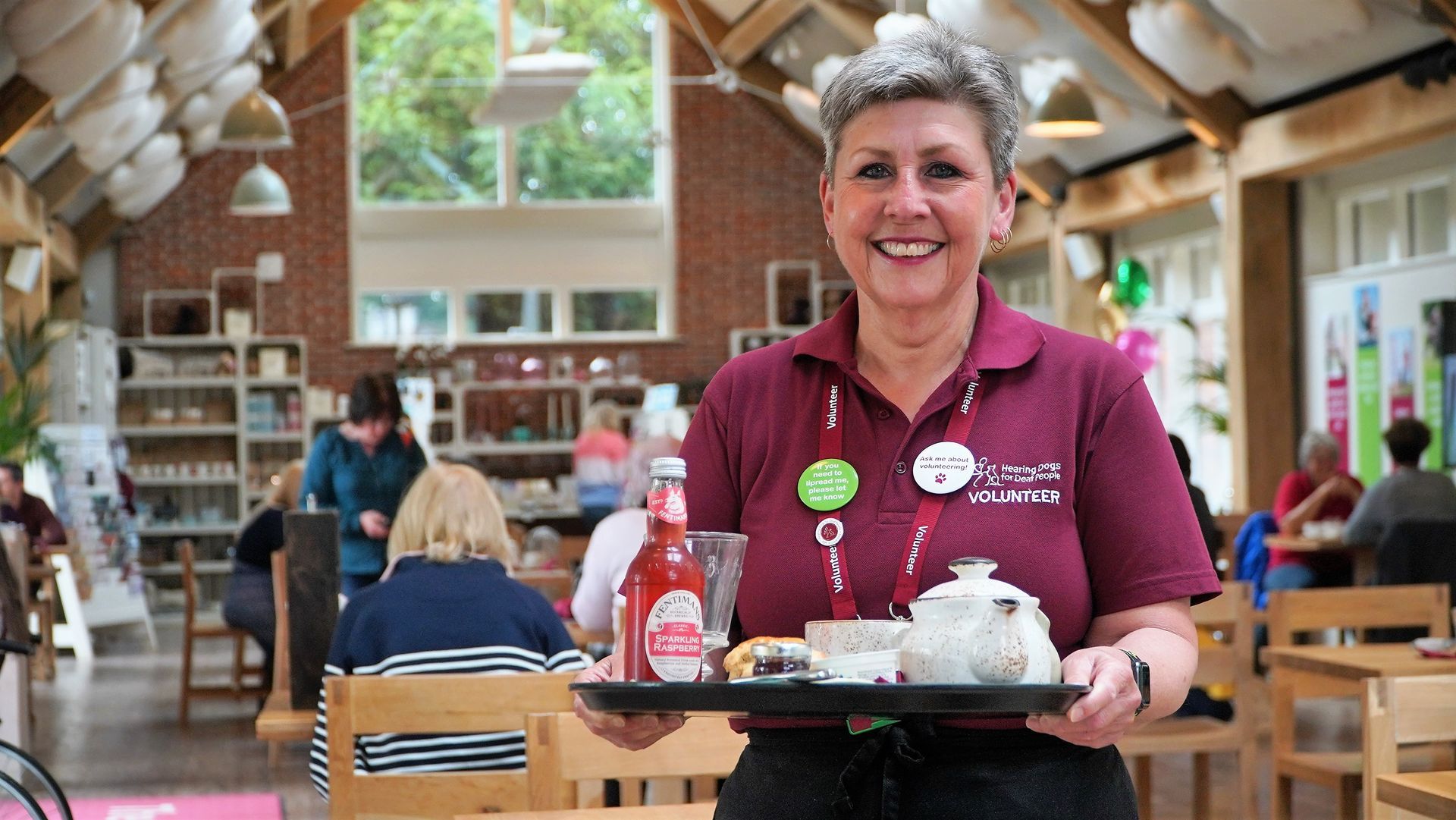 Front of House volunteer at The Grange restaurant, Anne Burton with a tray of tea and cakes.
Every person visiting The Grange is directly supporting the training of a life-changing hearing dog.