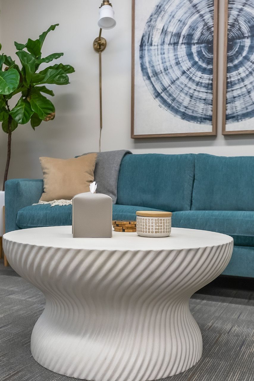 Therapy setting with a blue couch and a white coffee table