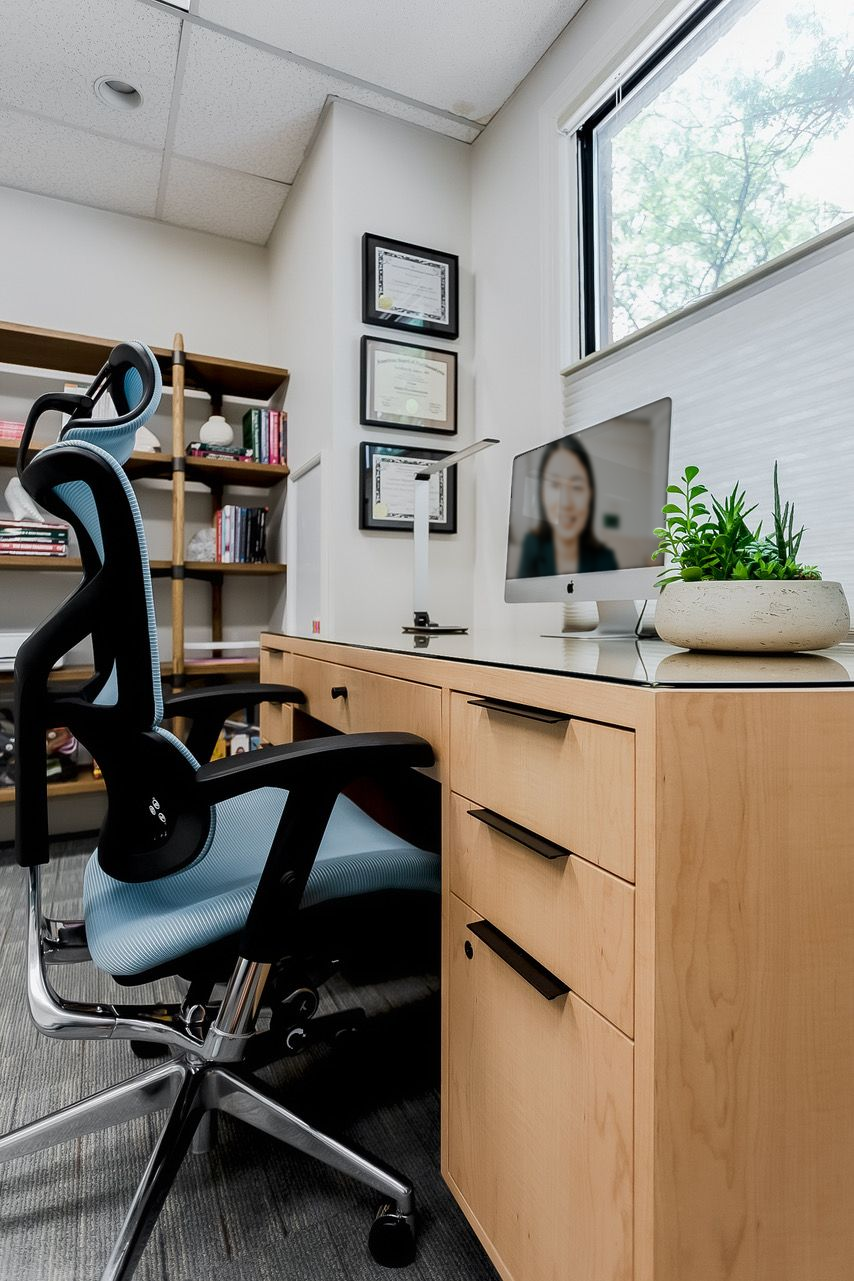Online Therapy setting with a computer and a chair in an office.