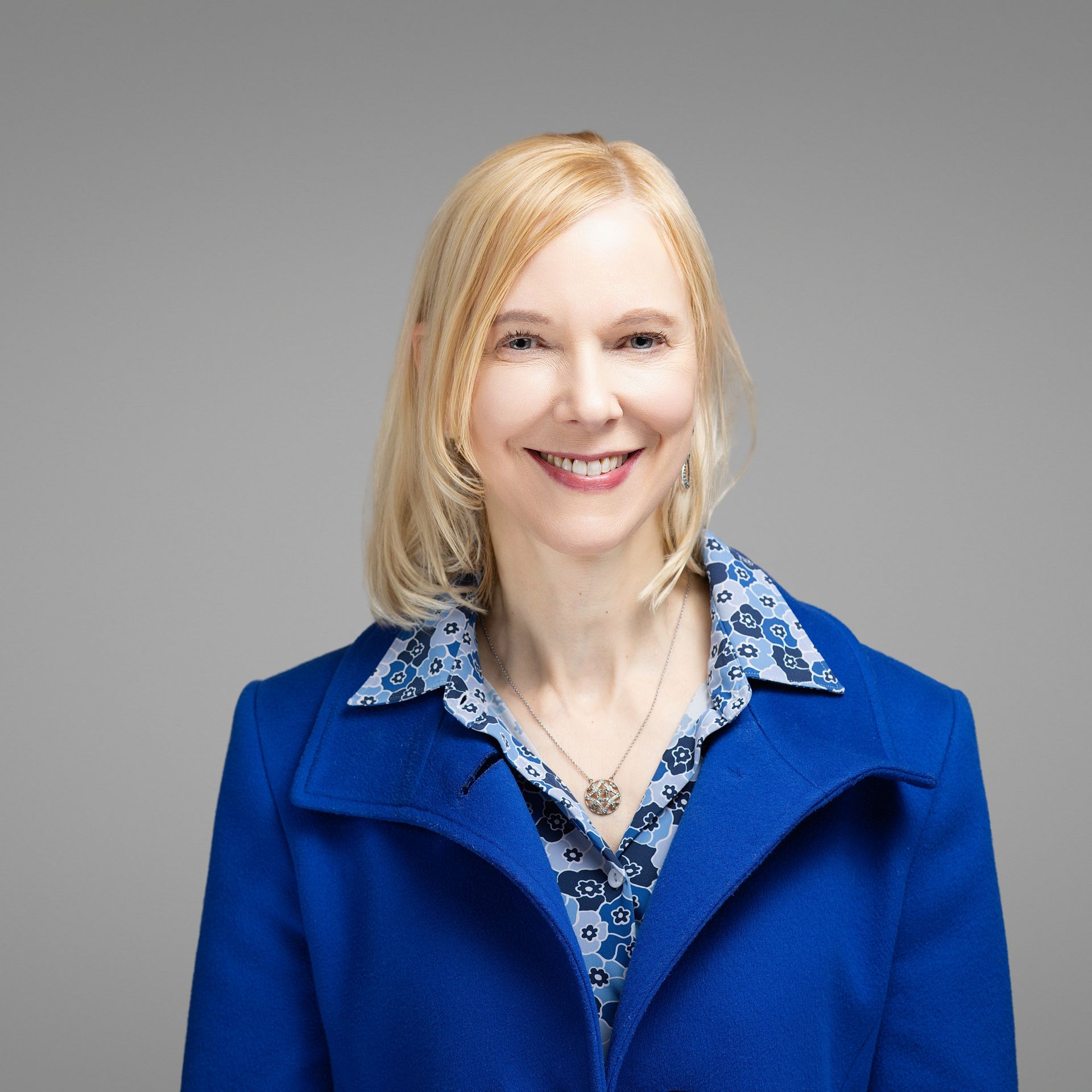 Golden Gate Bridge at sunset, with its iconic orange towers and cables stretching across the water. City skyline in background.