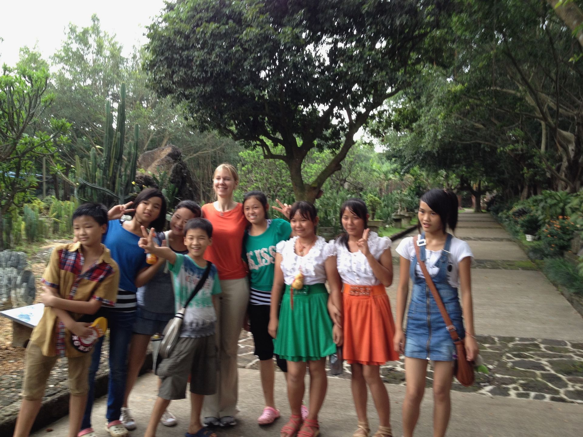A group of people posing for a picture with one girl wearing a green shirt that says ' kiss ' on it