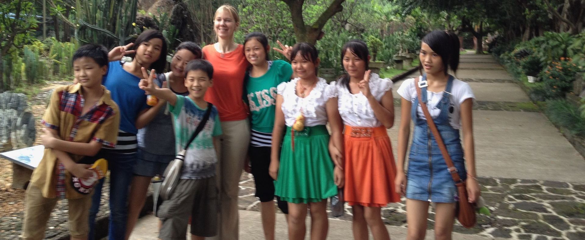 A group of people standing next to each other on a sidewalk.