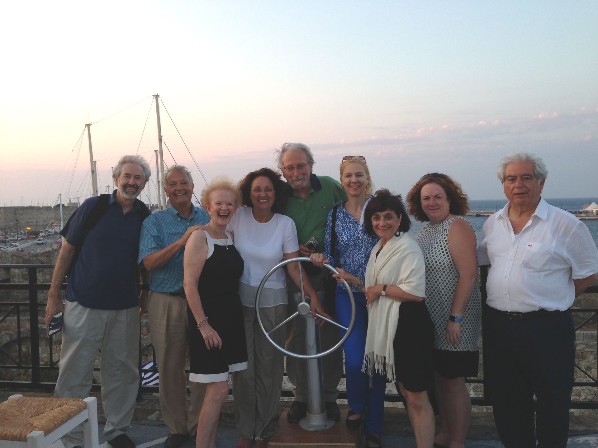 A group of people posing for a picture with a steering wheel in the middle