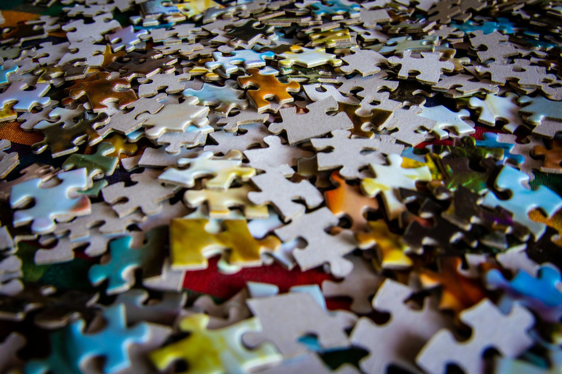 A bunch of puzzle pieces are scattered on a table