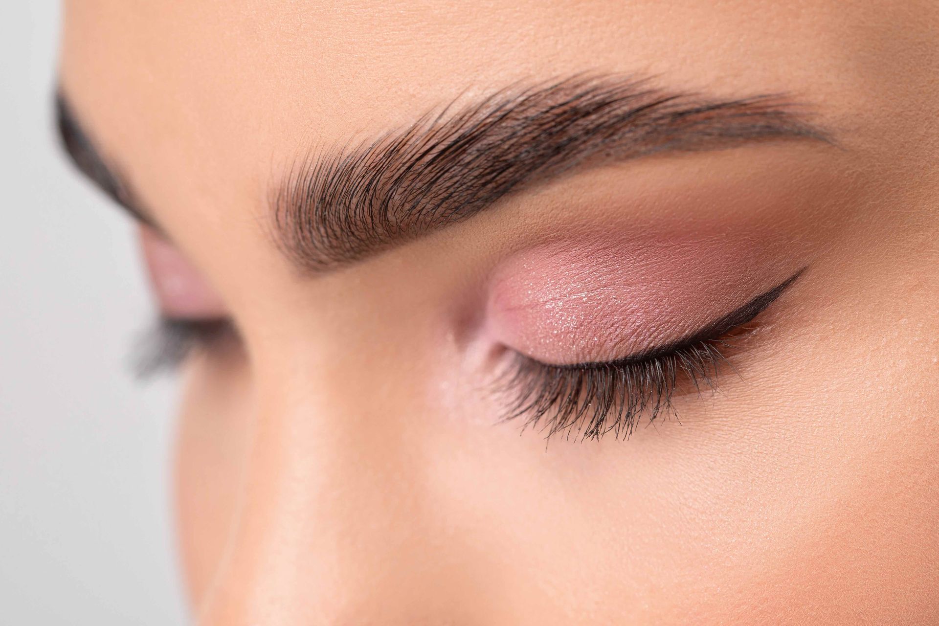 a close up of a woman 's eye with pink eyeshadow .