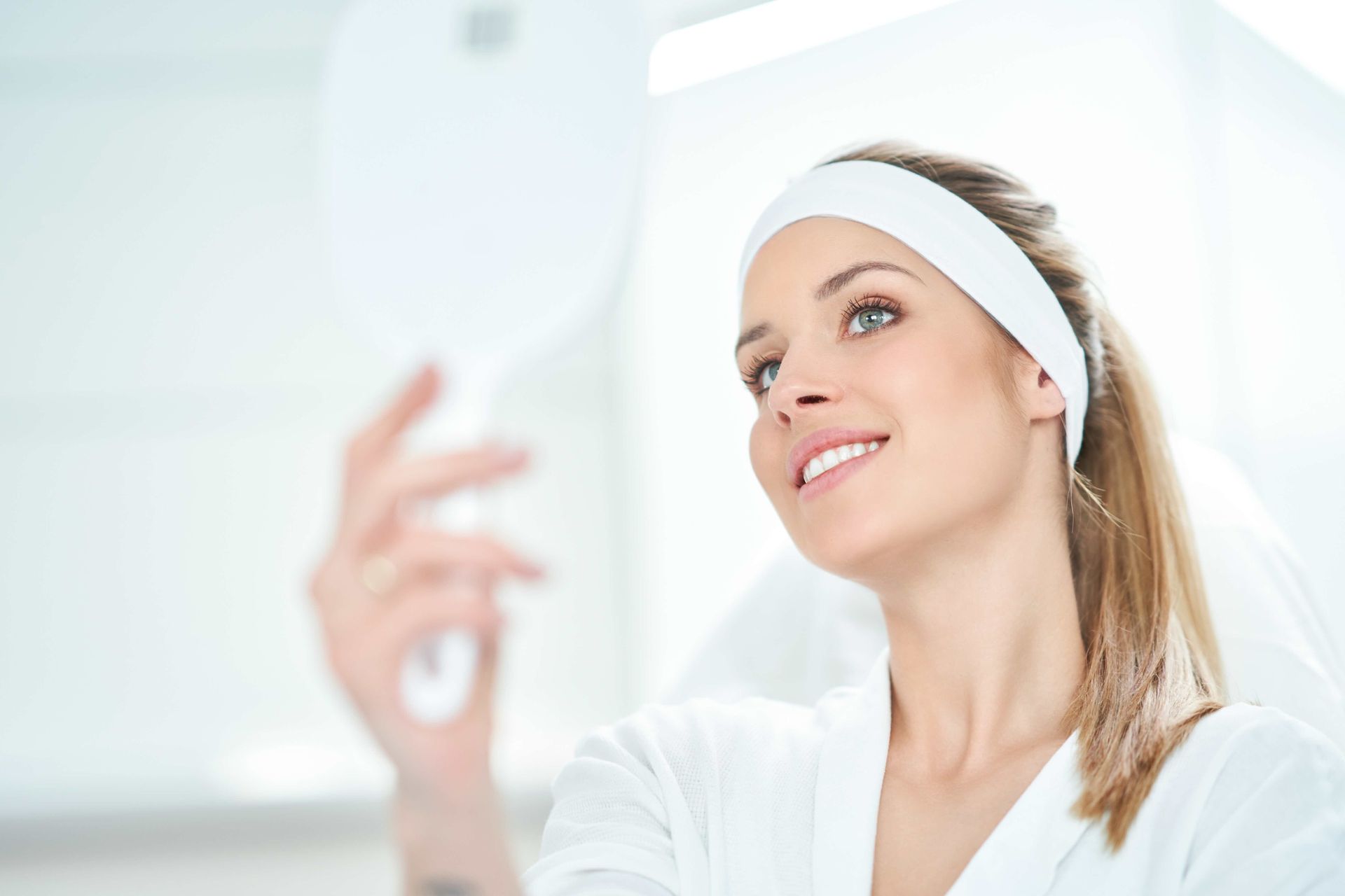 a woman is taking a selfie in front of a mirror .