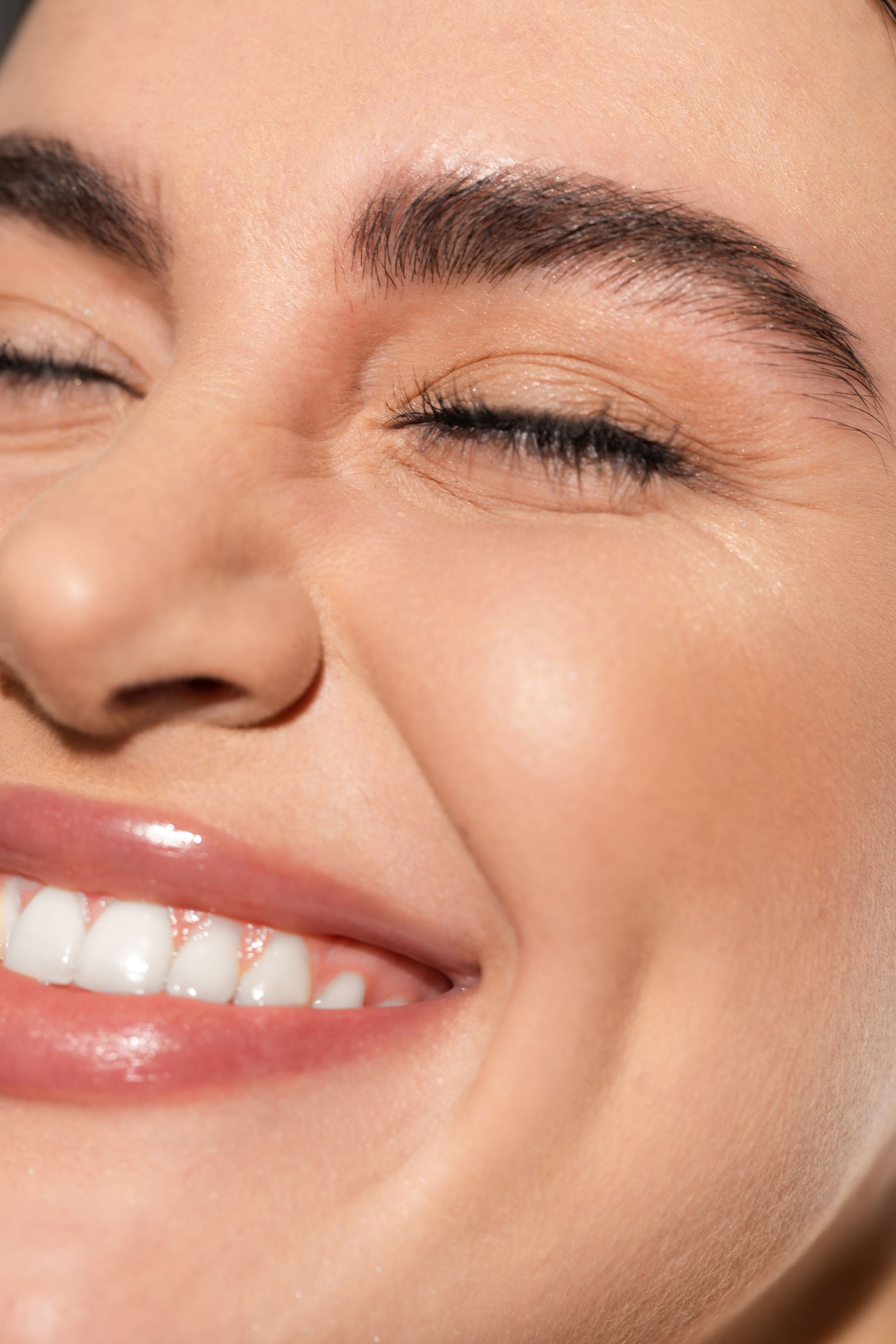 a close up of a woman 's face smiling with her eyes closed .