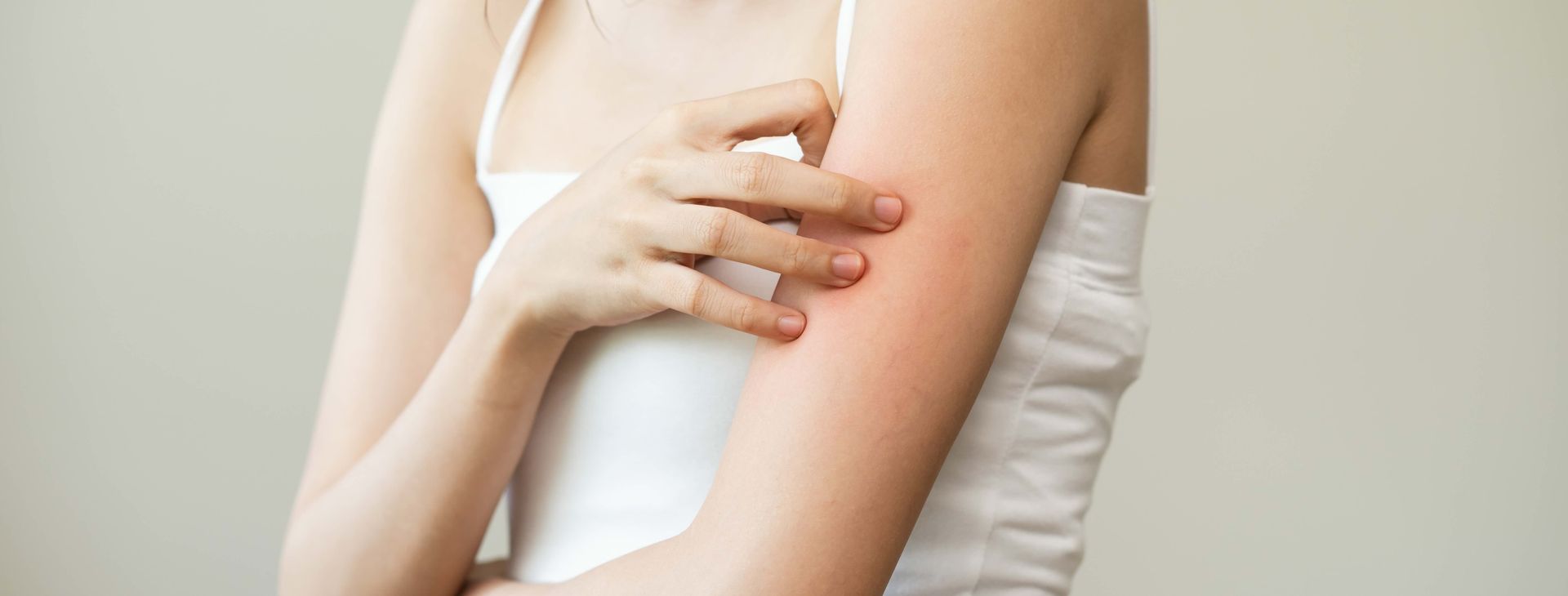 a woman is scratching her arm with a spray bottle .