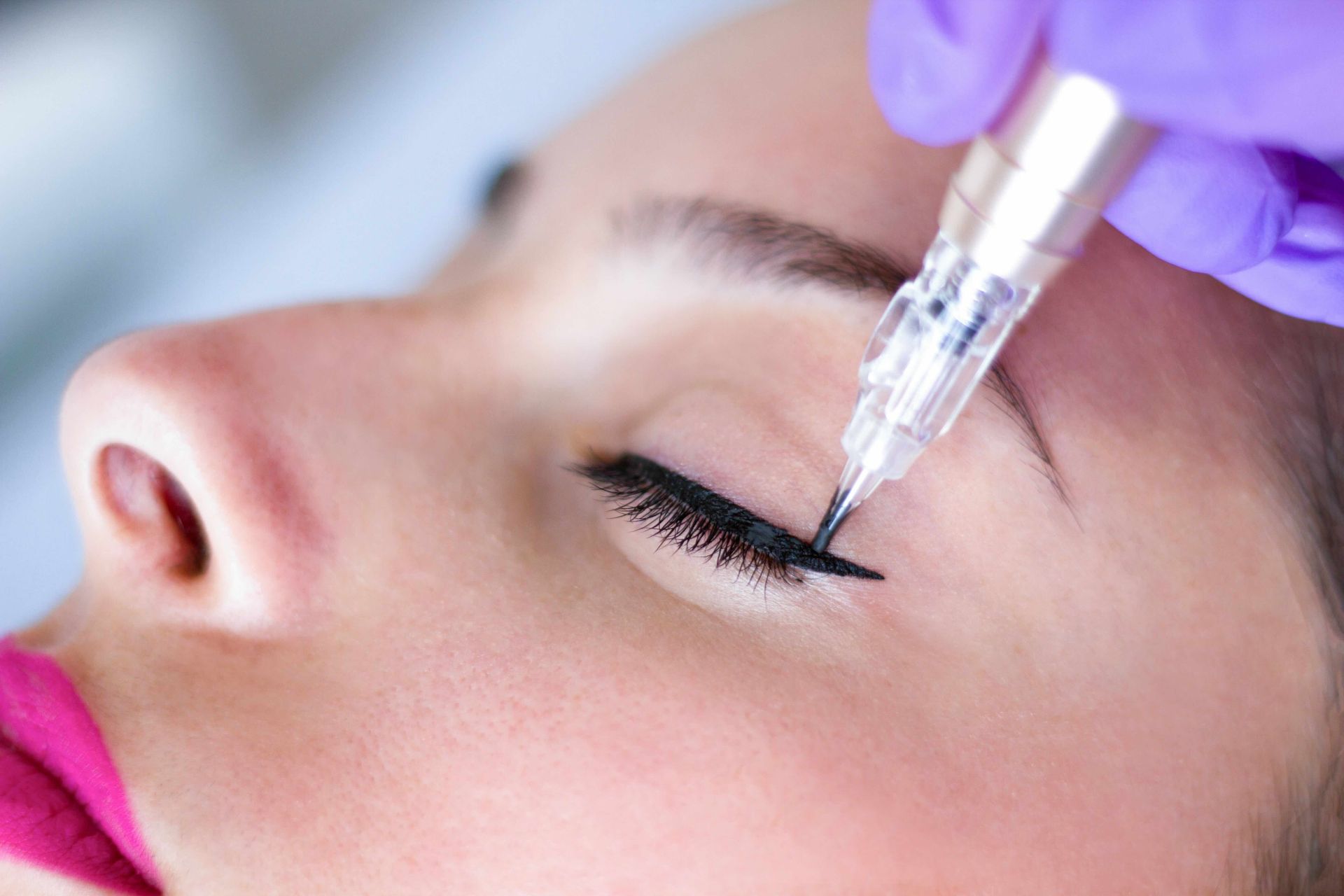 a woman is getting a permanent eyeliner tattoo on her eye .