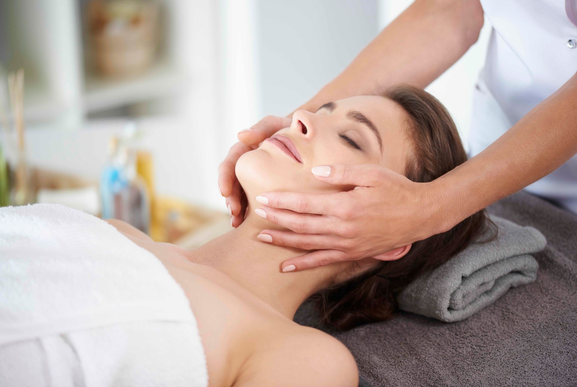 a woman is getting a facial massage at a spa .