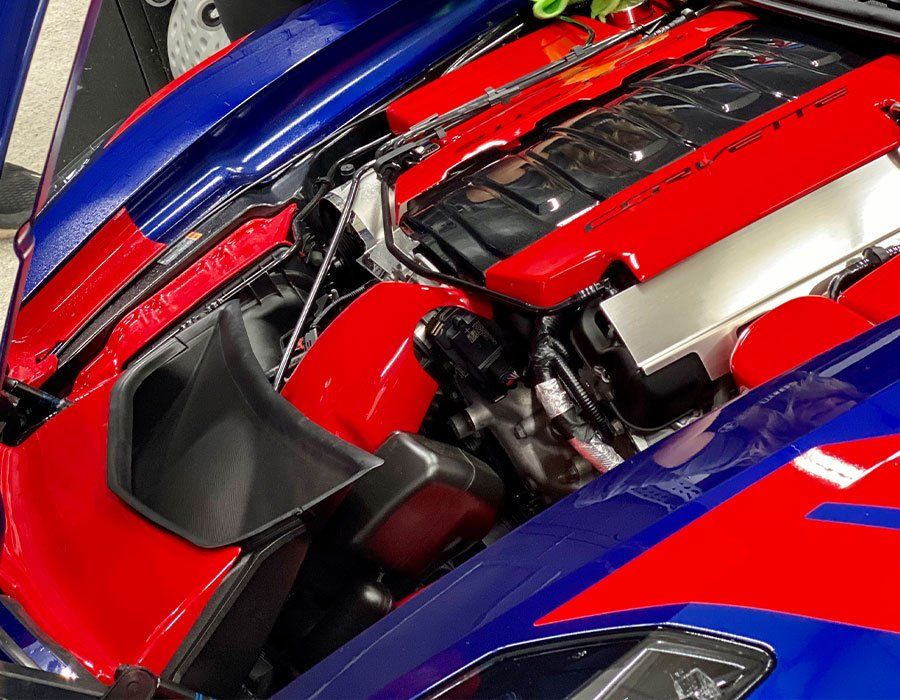 A red and blue sports car with the hood open