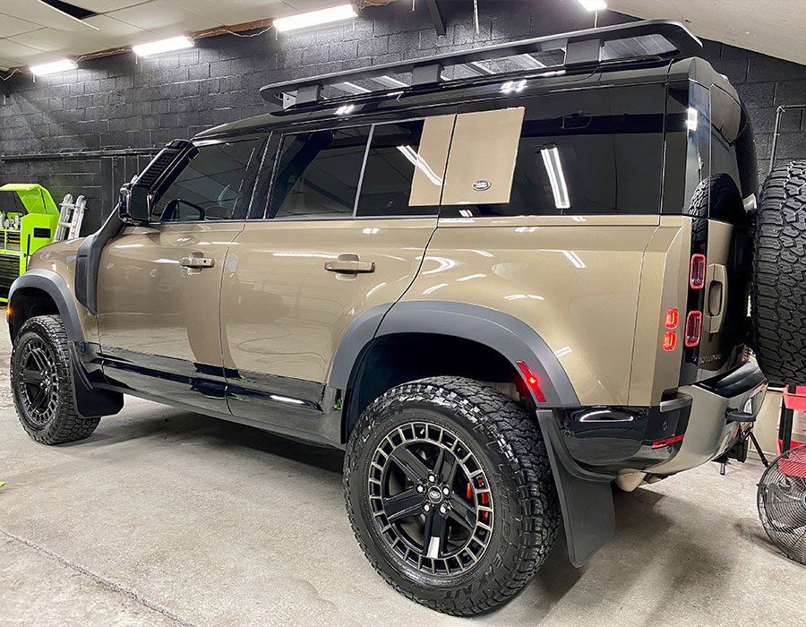 A land rover defender is parked in a garage.
