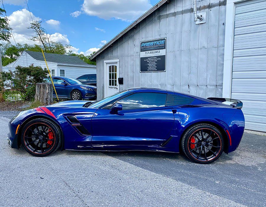 A blue corvette zr1 is parked in front of a garage.