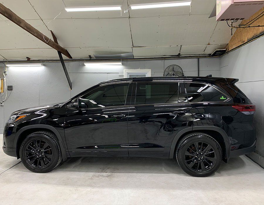 A black suv is parked in a garage.