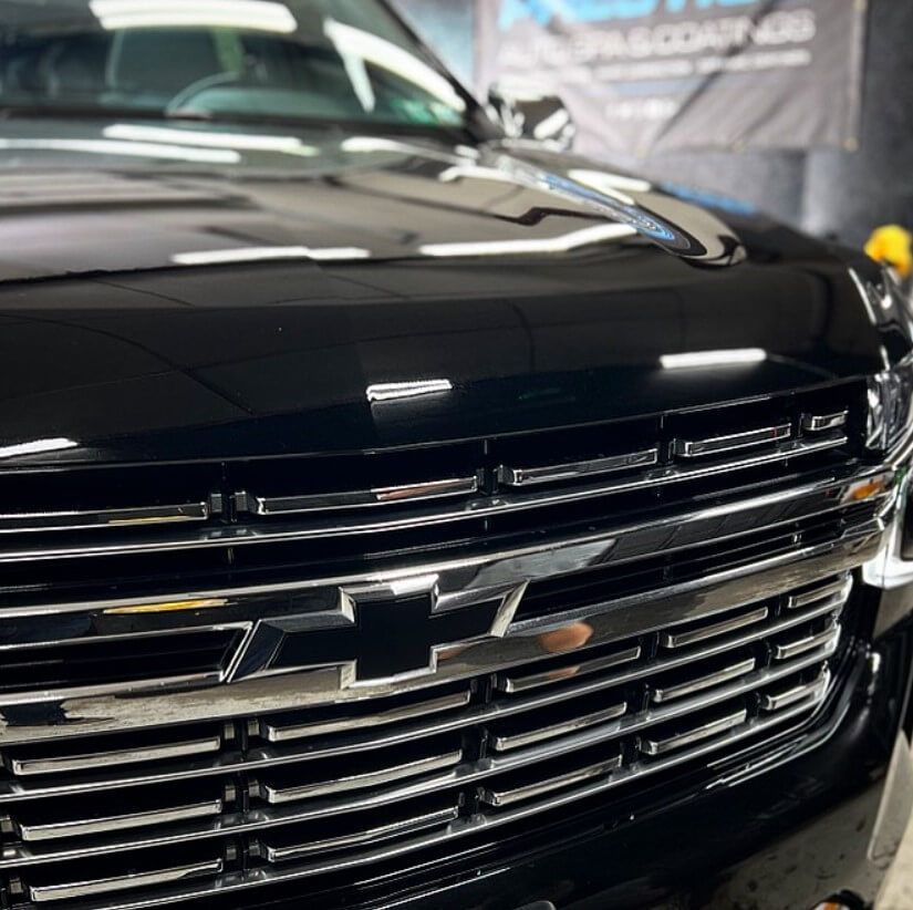 A black chevy truck is parked in a garage