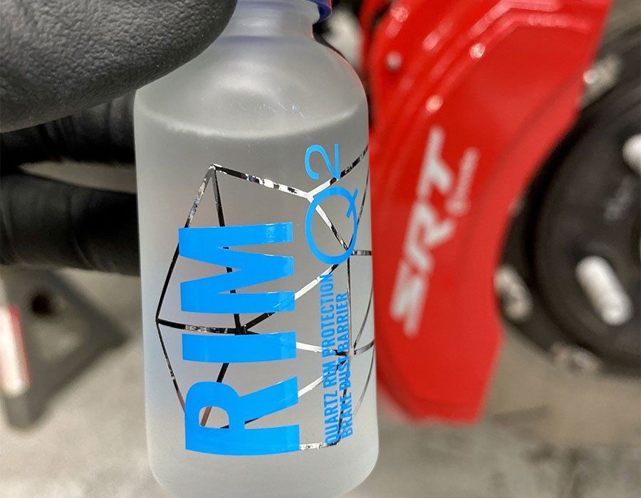 A person is holding a bottle that says rim on it