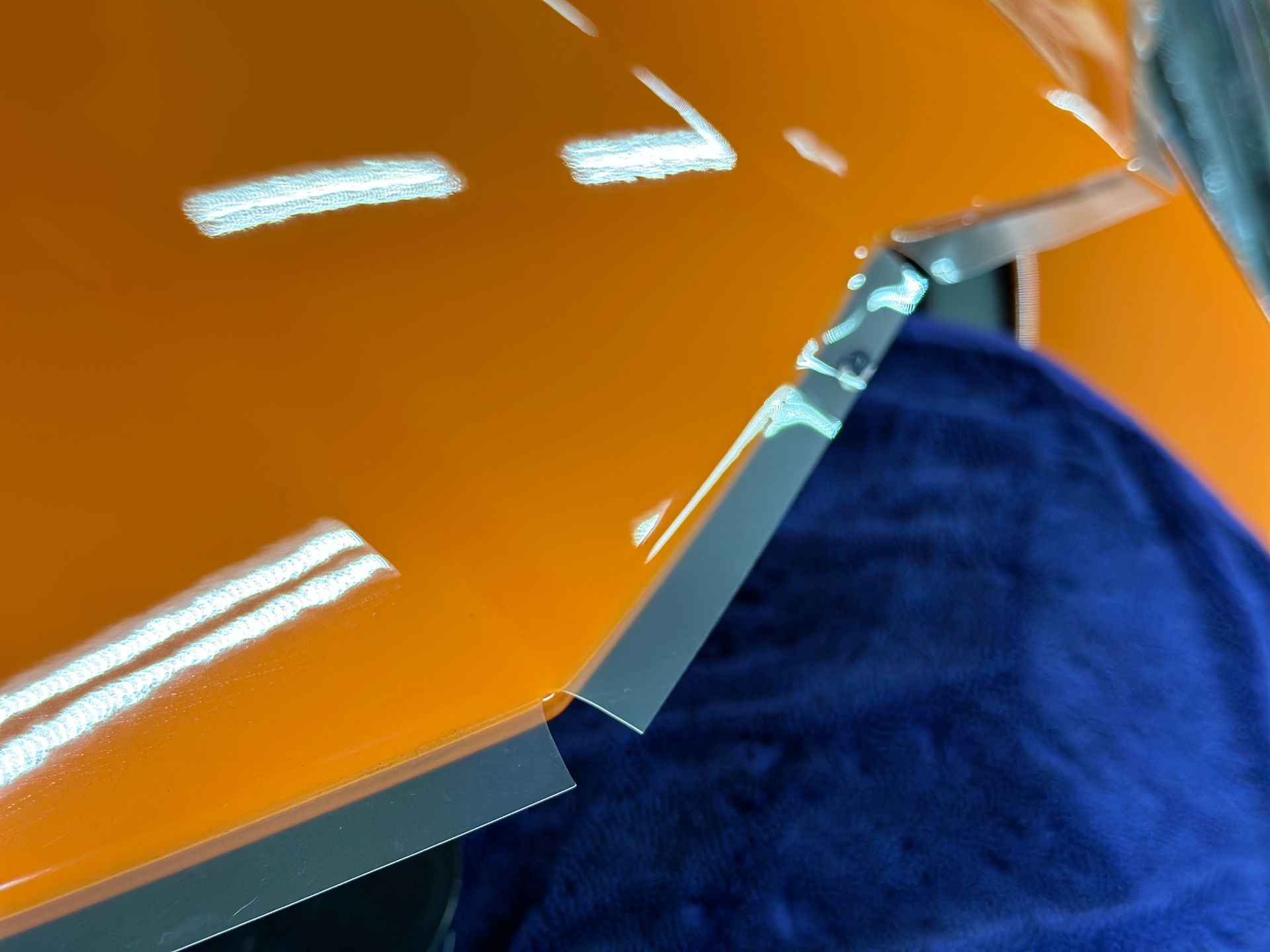 A close up of a piece of orange plastic on a blue cloth