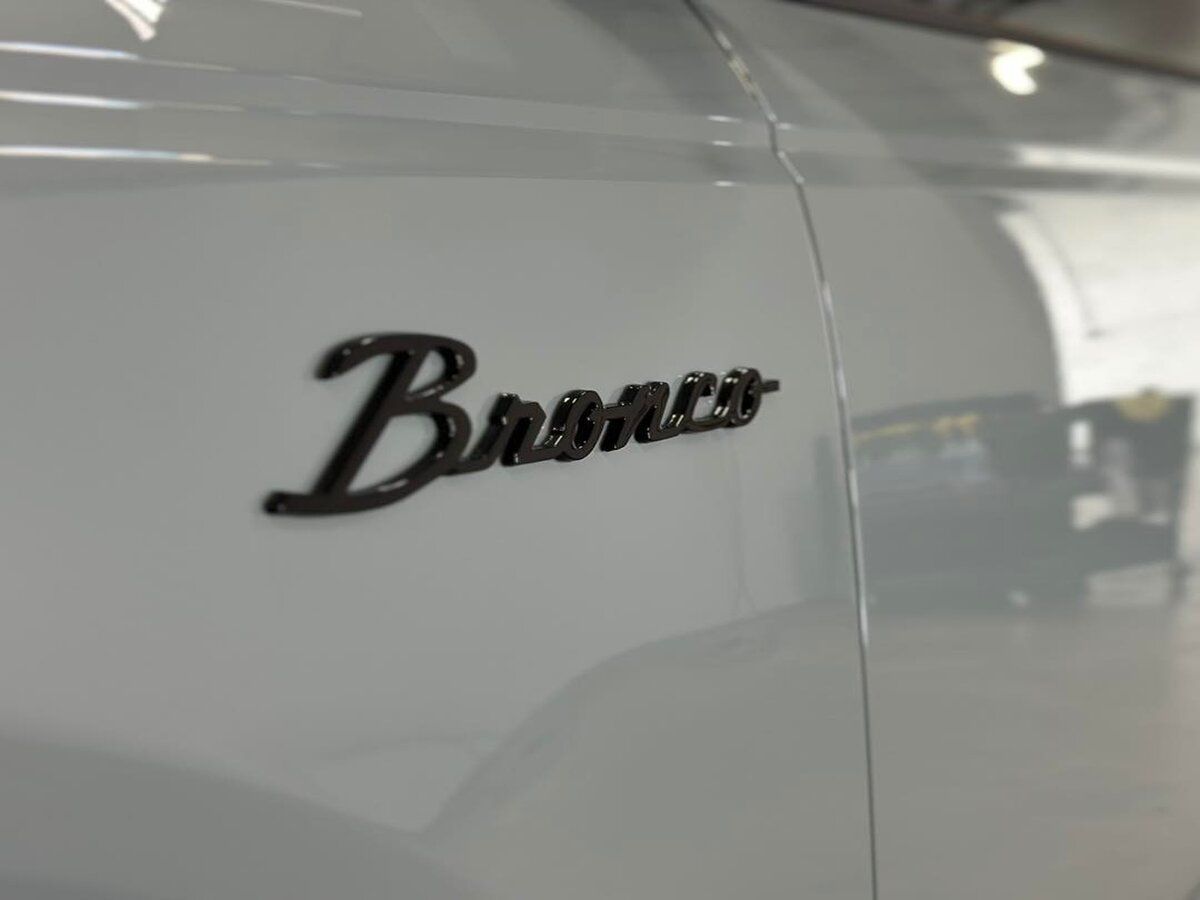 A grey bronco is parked in a garage.