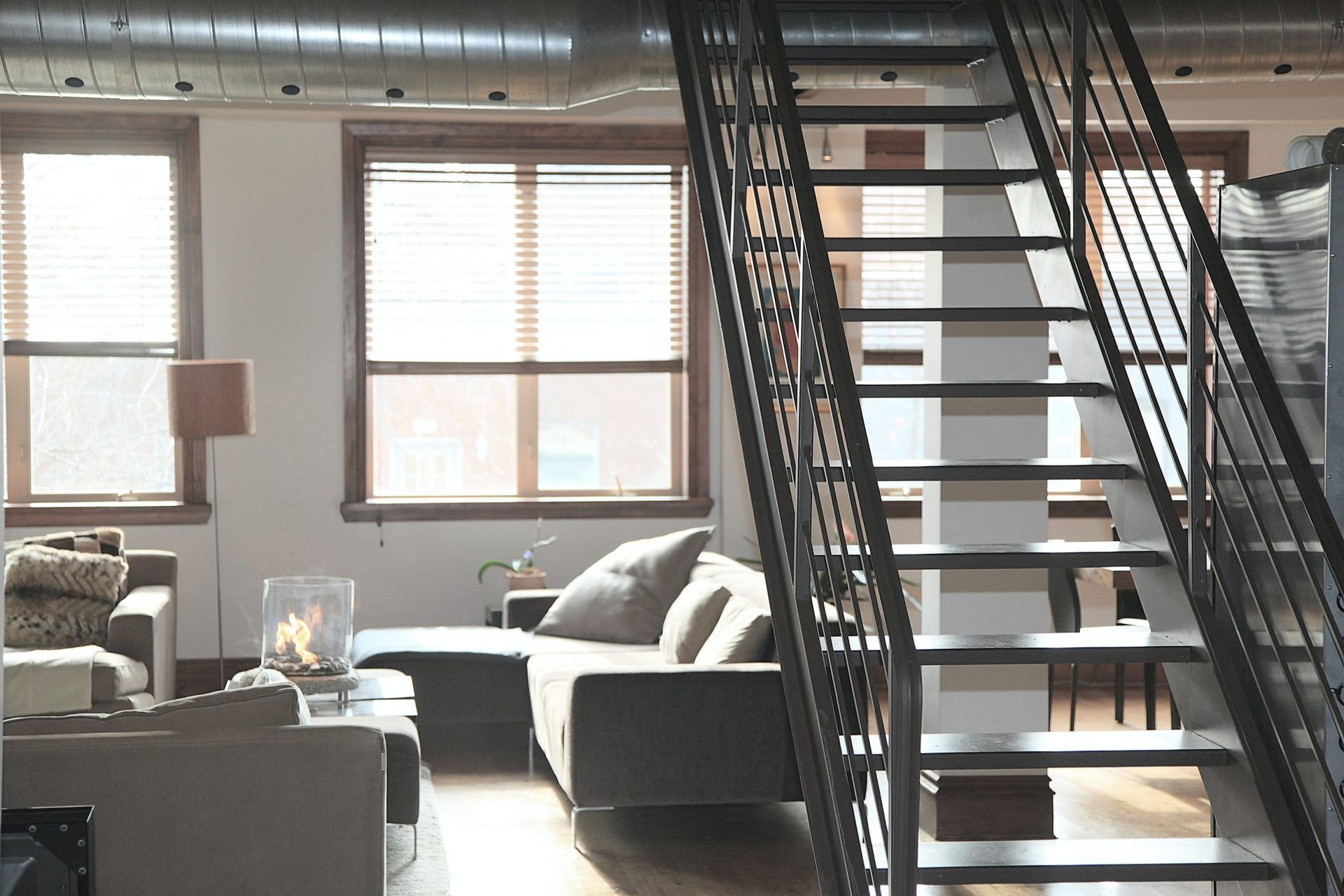 A living room with a staircase leading up to the second floor.