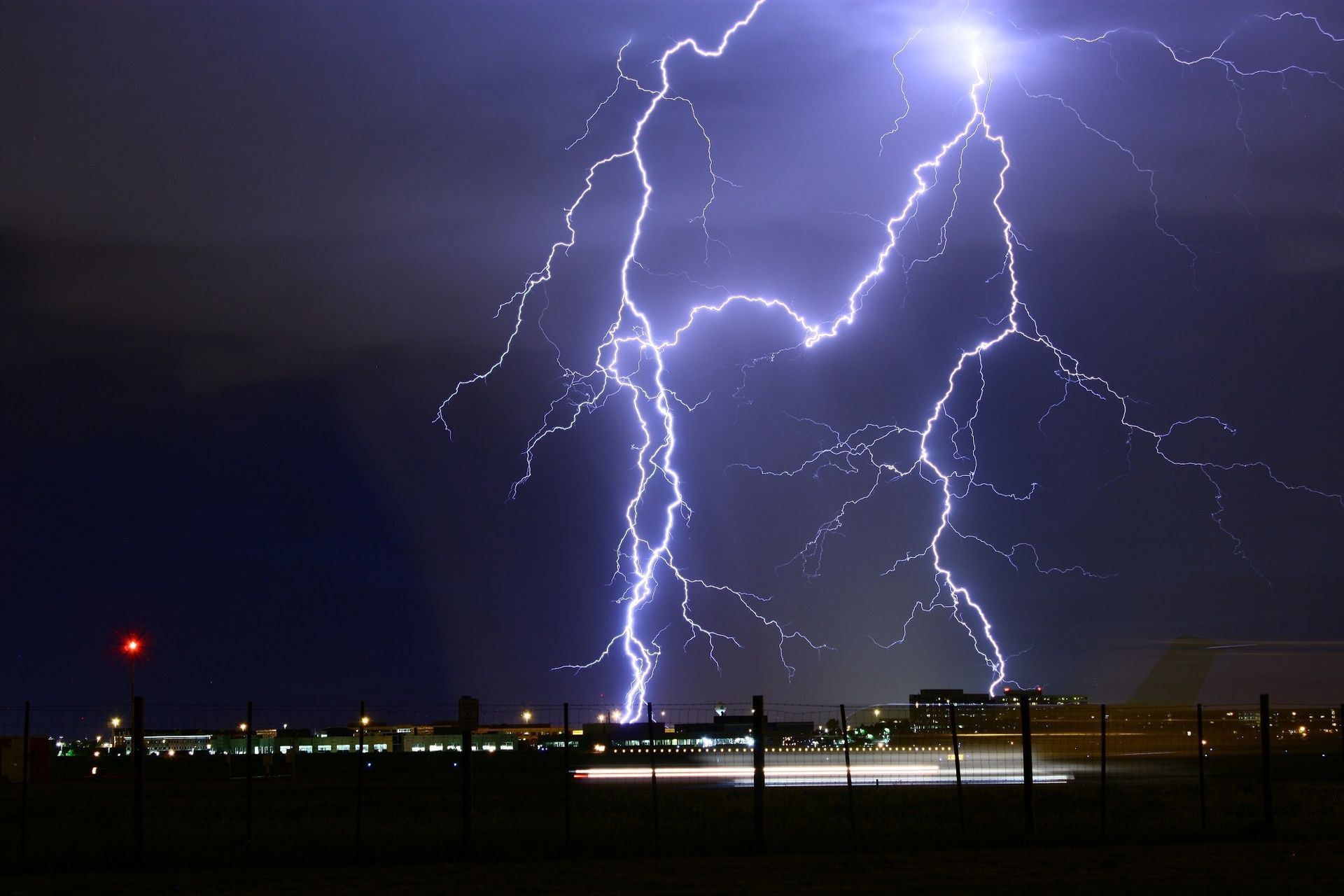 Lightning strikes in the night sky over a city