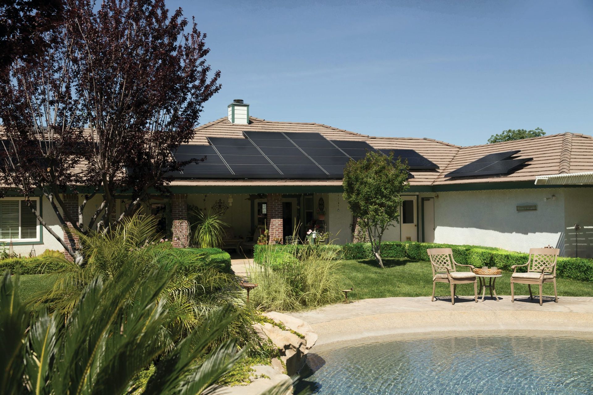 A house with solar panels on the roof and a pool