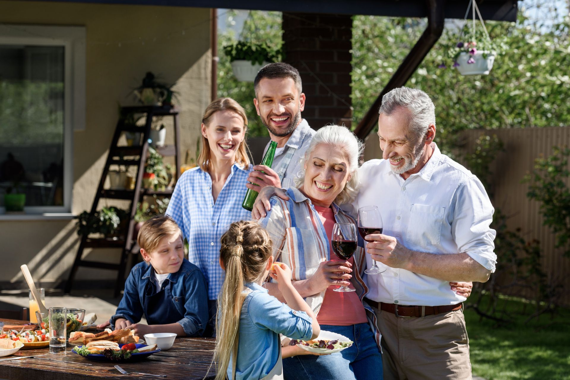 A family is sitting at a table eating food and drinking wine.