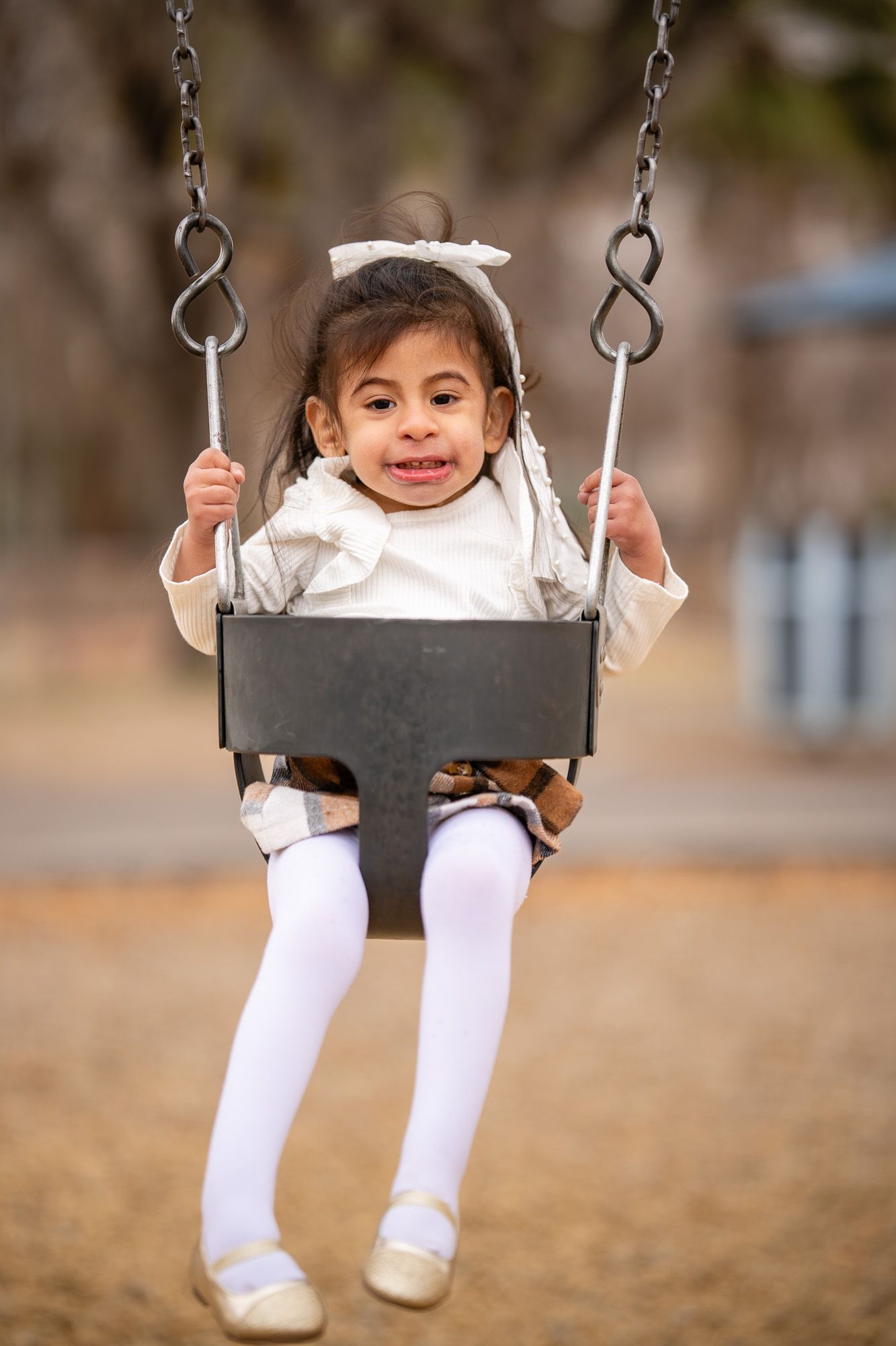 Joyful young girl on a swing, symbolizing Aprendamos Family of Services’ core values of putting families first.