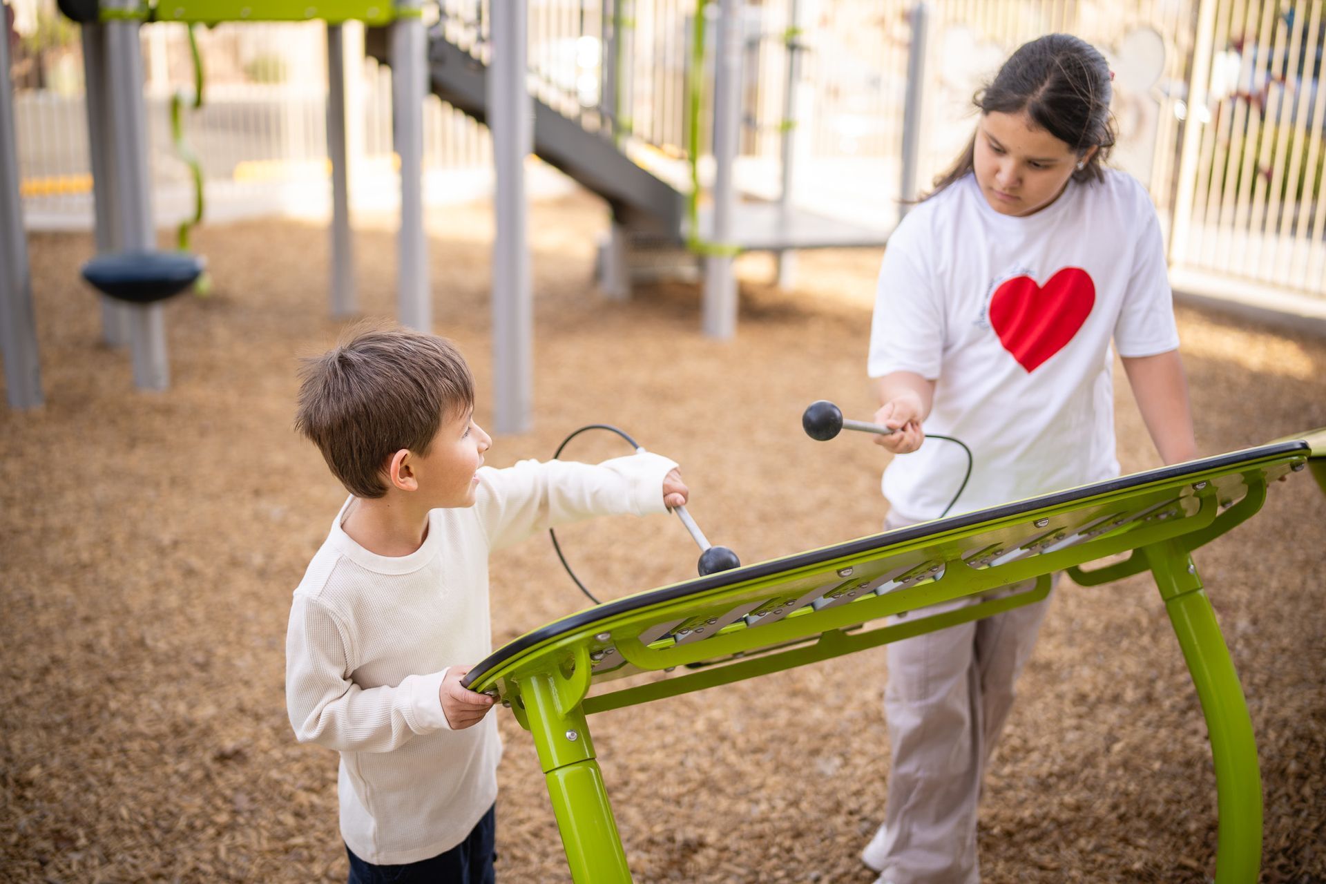 Two young children playing on a playground at Esperanza Children’s Therapy